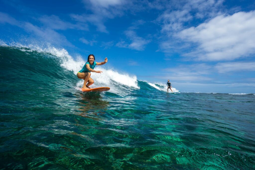 Girl riding on a surfboard learning how to surf.