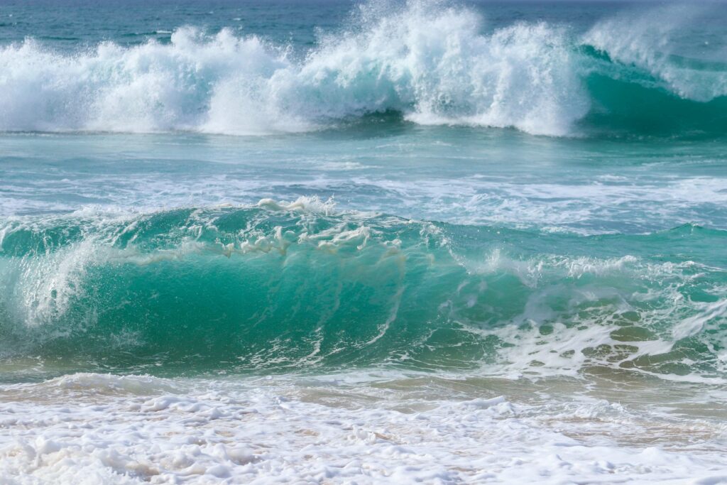 Barrel waves breaking on shore during high tide
