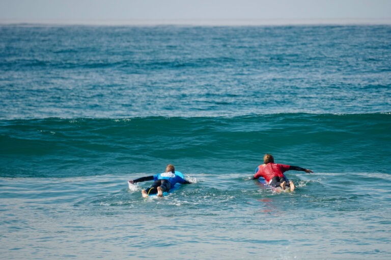 Surf instructor teaching a student how to drop in on a wave.