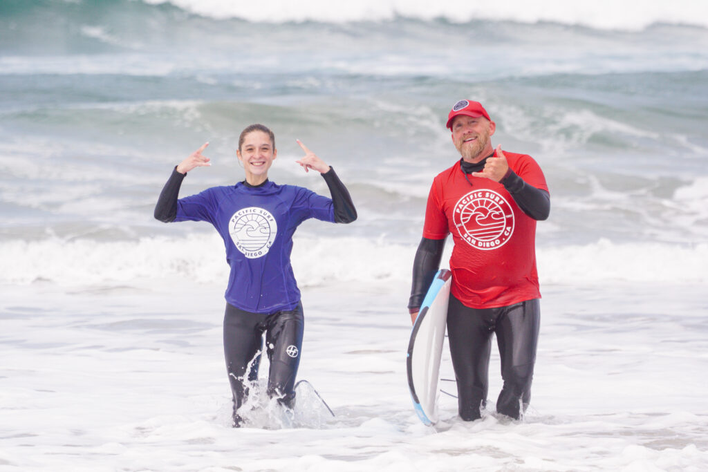 Surf student and instructor exiting the water after a surf lesson