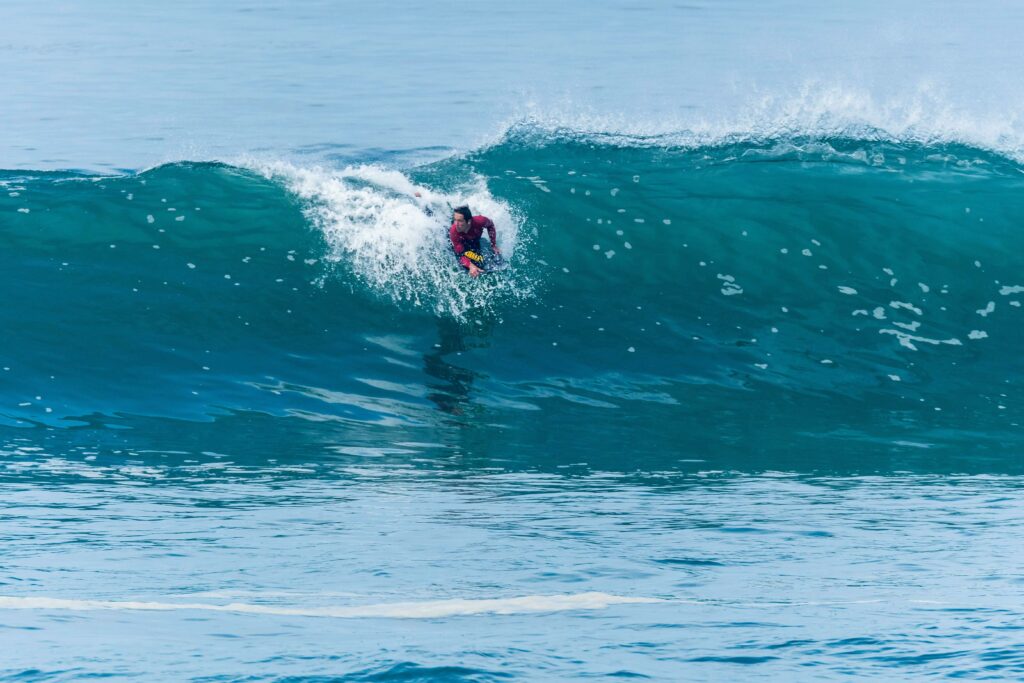 Surfer catching a wave, getting ready to pop up