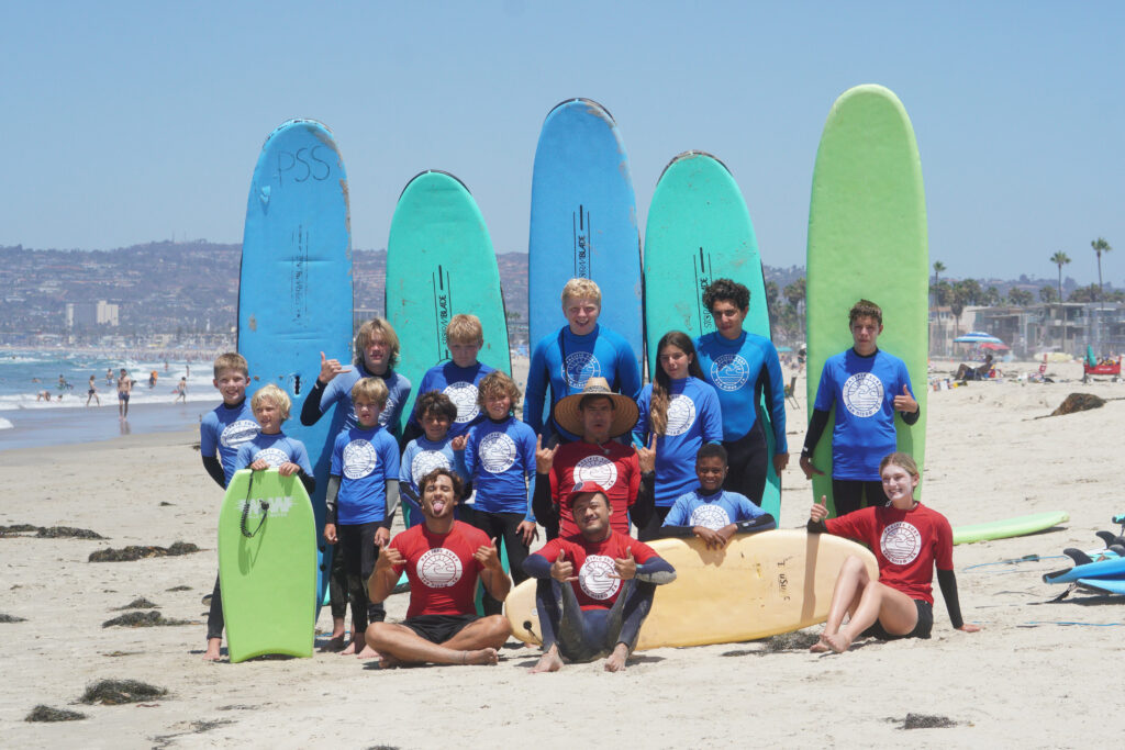 Students and instructors from Pacific Surf School on the sand with their ideal surfboard