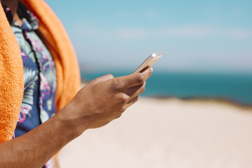 Women surfer using mobile phone at the beach